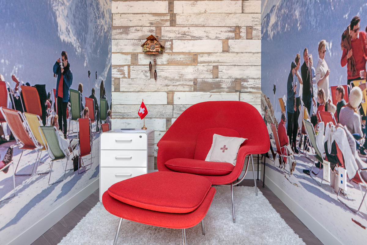 A cozy nook decorated Swiss with a Swiss chair, flag and picture