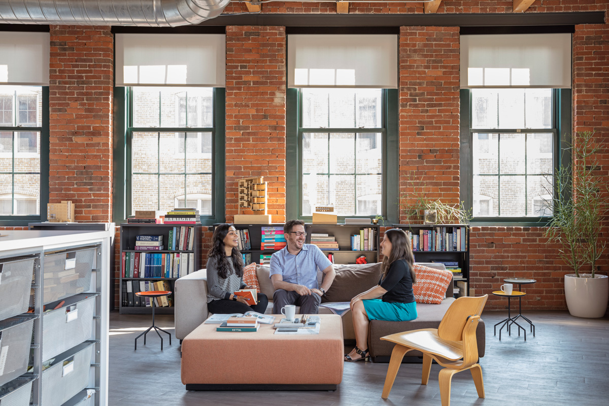 Hacin + Associates office lounge with couches and bookshelves