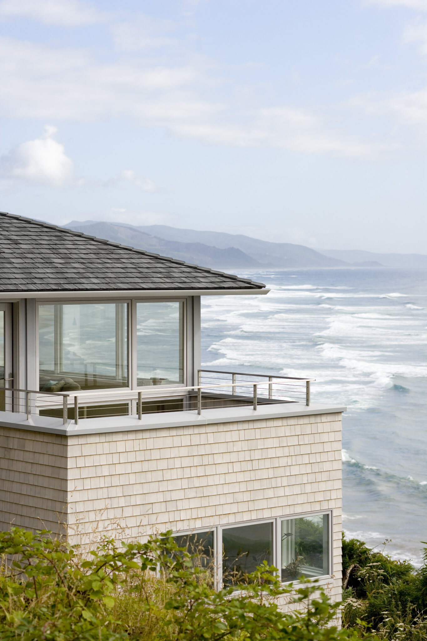View of white coastal home with ocean in background
