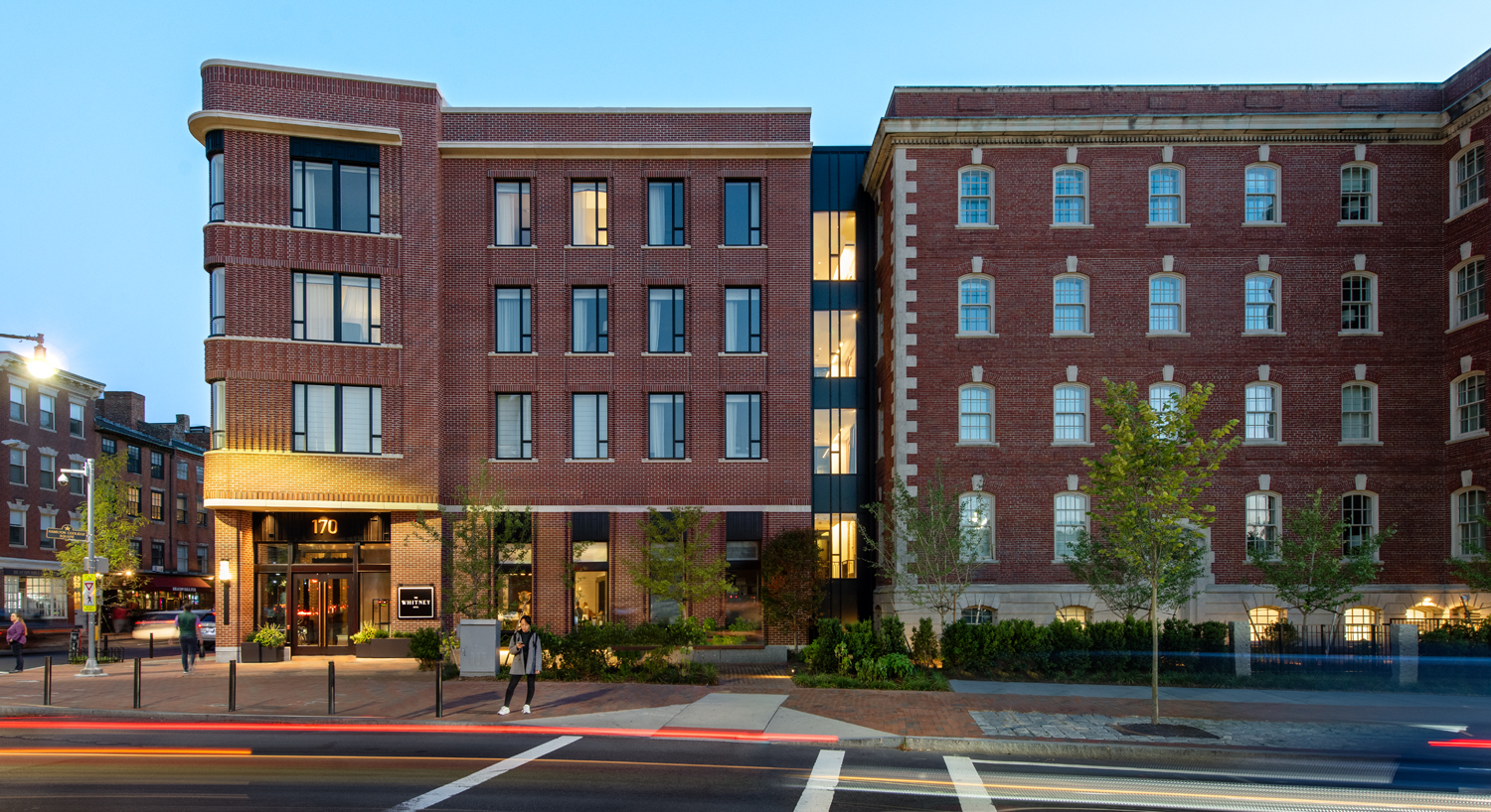 Street view of the Whitney hotel brick building and a guest