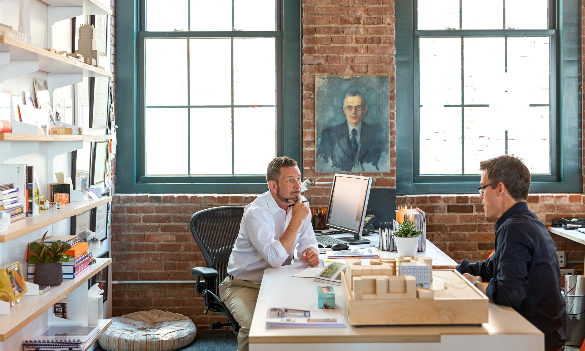 Hacin + Associates' president, David Hacin sitting at his desk