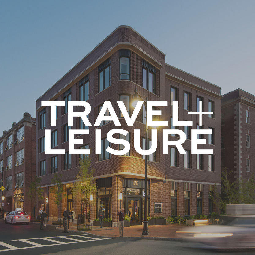 Travel + Leisure logo with brick commercial building background